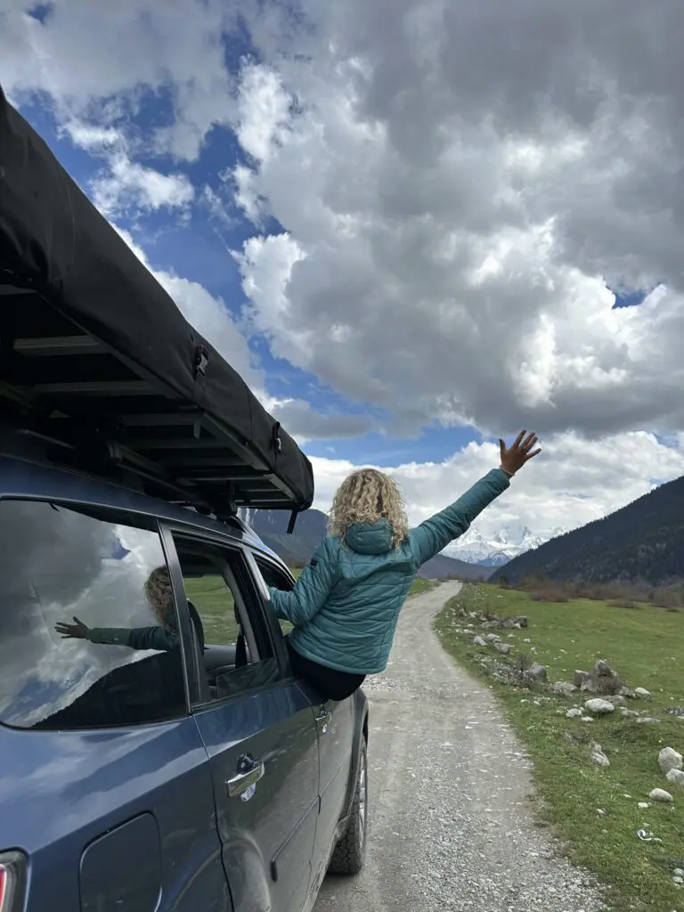 woman leaning out of car window on a dirt road in Georgia