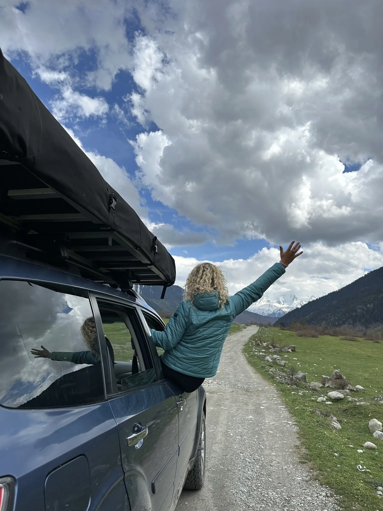 woman leaning out of car window on a dirt road in Georgia