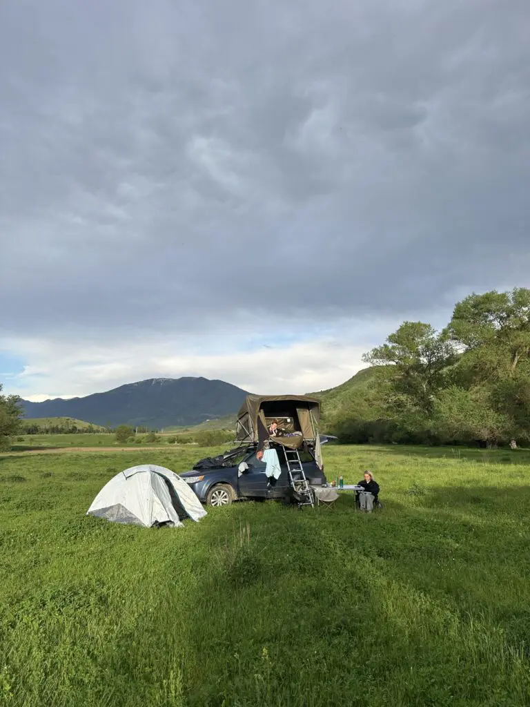camping in a green field with a rooftop tent and ground tent