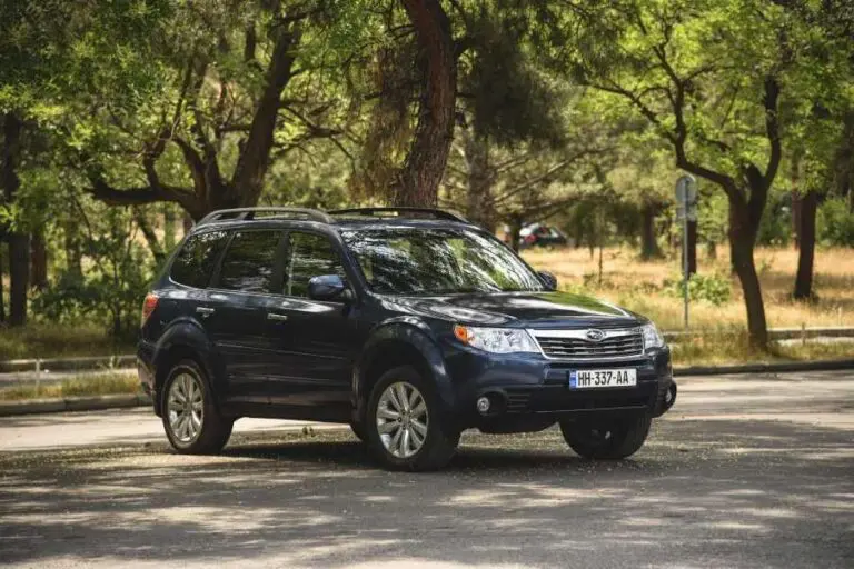 dark blue Subaru Forester SUV parked in a wooded area
