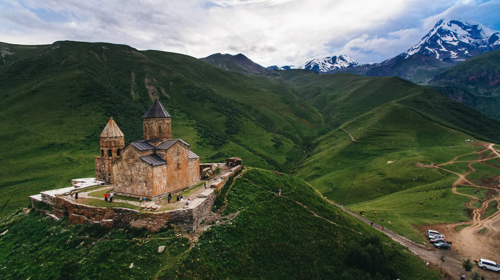 aerial view of Gergeti Trinity Church in green mountains