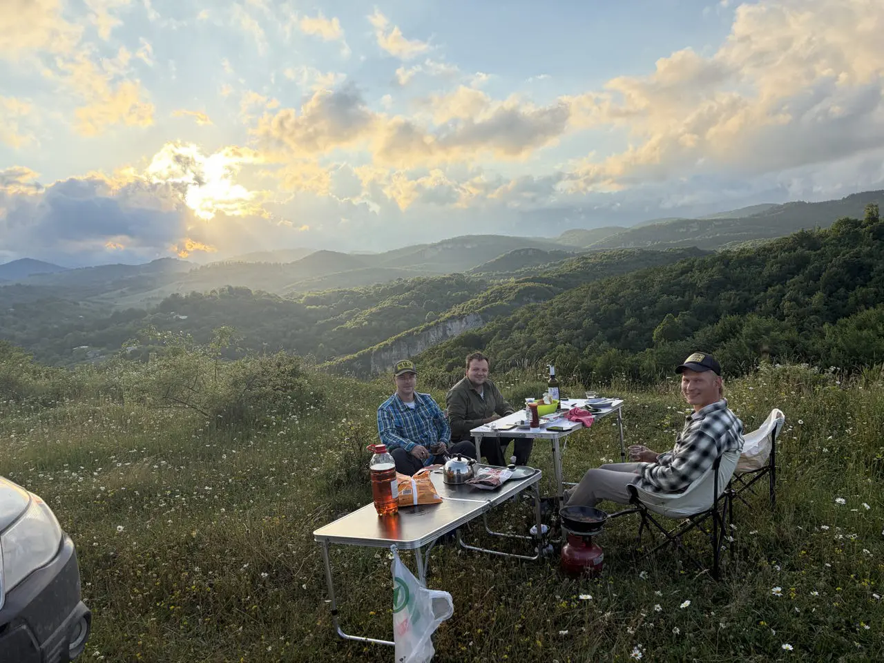 three men camping in mountains at sunset in Georgia