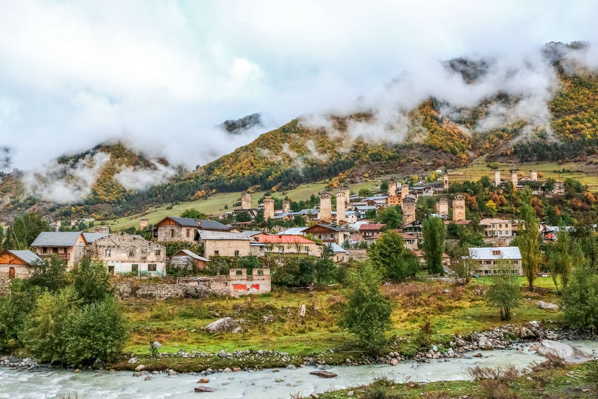 Village perché dans les montagnes avec des nuages en Géorgie